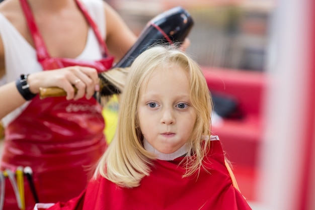 Una niña hace un corte de pelo.