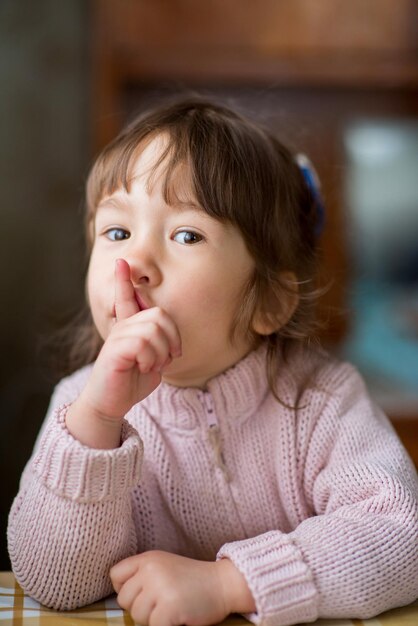 La niña hace un gesto con la mano.