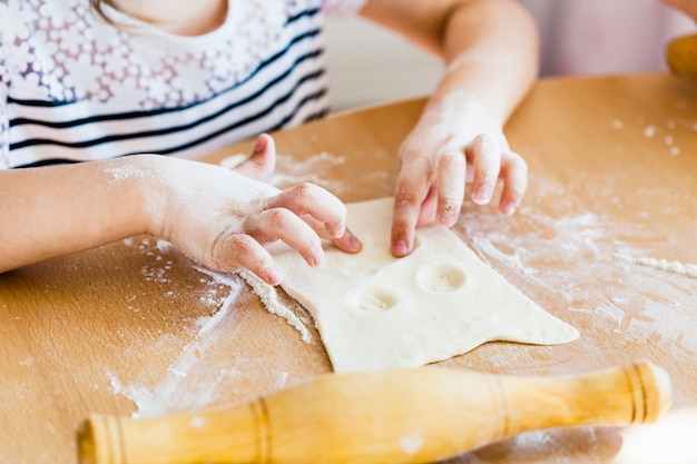 la niña hace masa de hojaldre, rodillo, harina, horneado, cocina con masa y harina