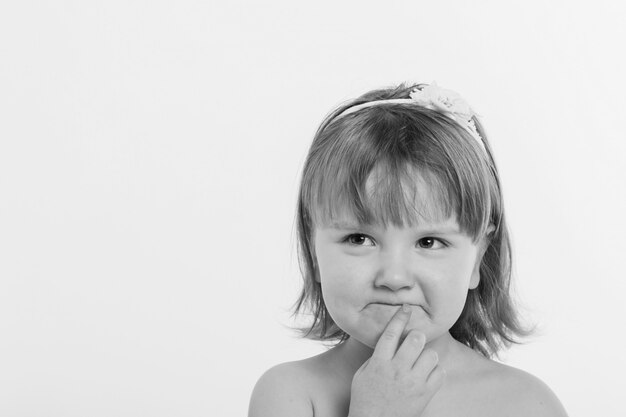 Una niña hace muecas contra un fondo blanco.