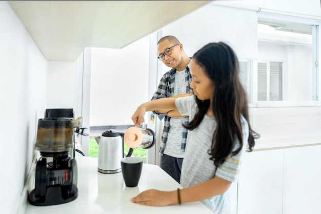 Foto niña haciendo café para su padre en casa