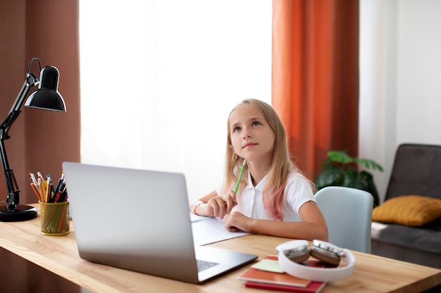 Foto niña haciendo clases online