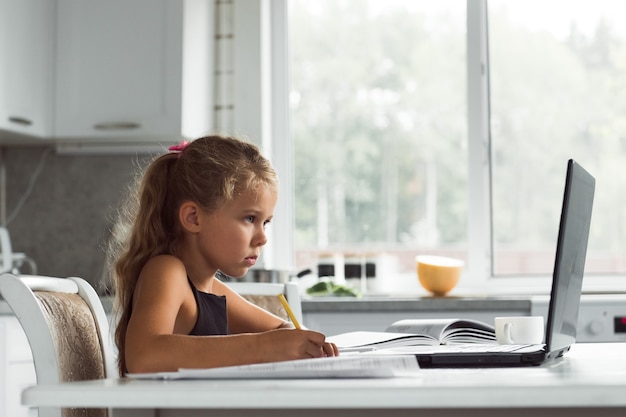 niña haciendo los deberes o aprendiendo en línea con la computadora portátil