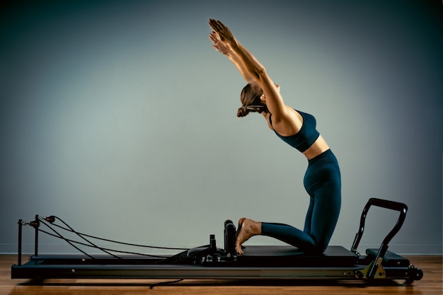 Niña haciendo ejercicios de pilates con una cama reformadora