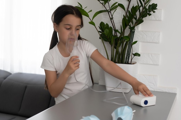 Niña haciendo inhalación con nebulizador en casa. niño asma inhalador inhalación nebulizador vapor enfermo tos concepto.