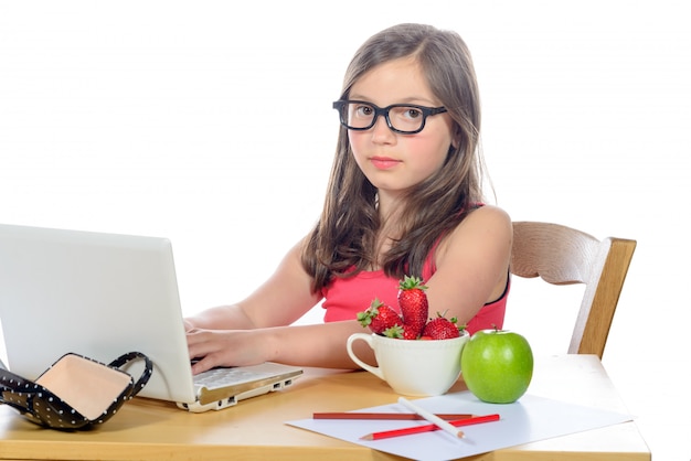 Una niña haciendo su tarea en su computadora