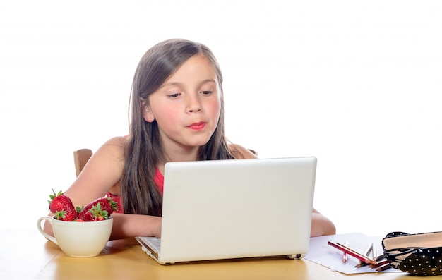 Una niña haciendo su tarea en su computadora