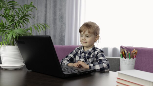 Niña haciendo la tarea en línea usando una tableta digital Educación a distancia