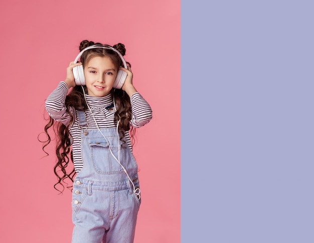 Niña hermosa escucha música con auriculares.