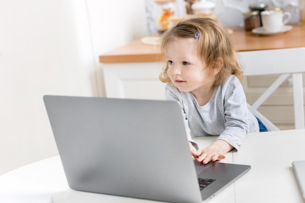 Niña hermosa estudia en casa mientras está en cuarentena Niño lindo haciendo la tarea en línea