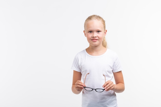 Niña hermosa con gafas sobre fondo blanco con espacio de copia