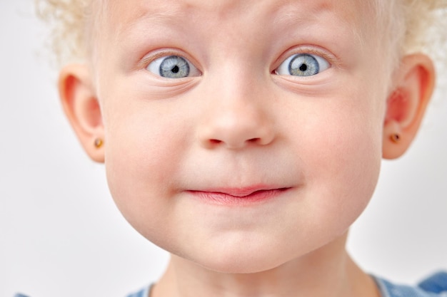 Niña hermosa niña con ojos muy abiertos mira a la cámara en ropa de productos para niños sorpresa y ac...