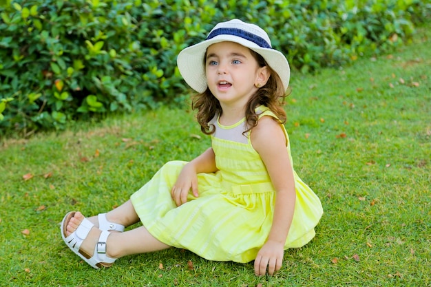 Niña hermosa niña con vestido amarillo en un parque de la casa de campo al aire libre Foto gratis