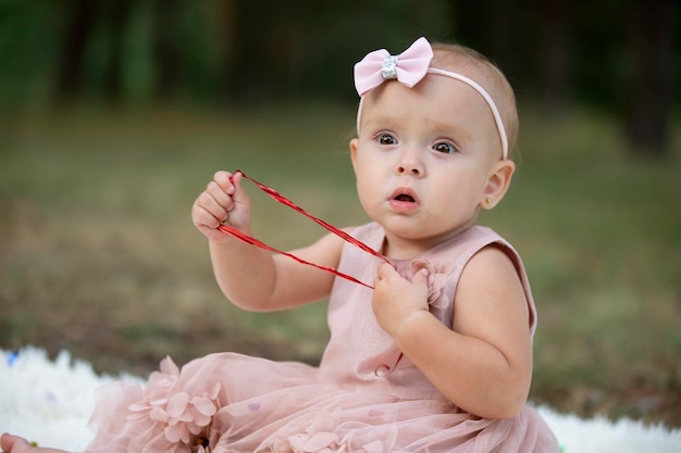 Una niña hermosa en un paseo en un parque de verano Niño de un año Dulce bebé