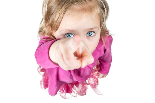 Una niña hermosa con el pelo desaliñado y los ojos azules muestra el pulgar hacia arriba, vista superior, aislada de fondo blanco