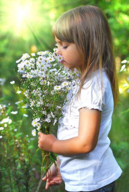 Una niña hermosa que huele a flor