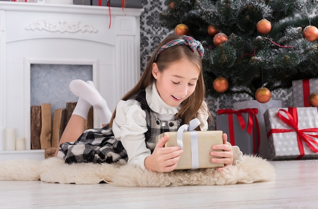 Niña hermosa y regalo de Navidad en el interior