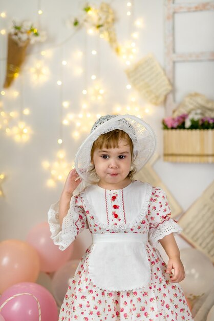 Una niña hermosa con un vestido de muñeca y un sombrero.