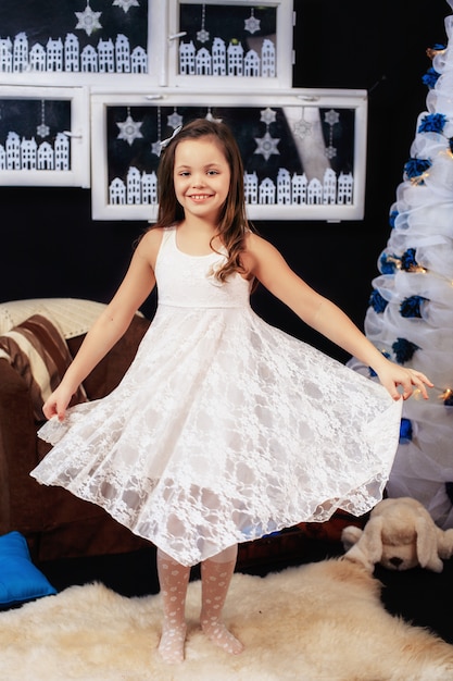 Niña en un hermoso vestido blanco. el año nuevo y feliz navidad