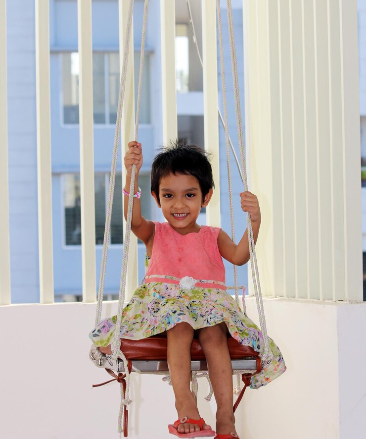 niña en un hermoso vestido sentada en un fondo rosa