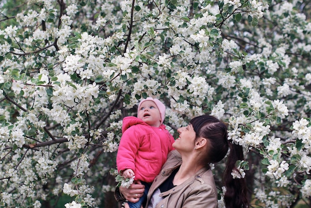 Niña con hija en un jardín de manzanas de primavera