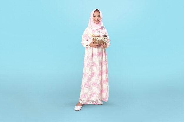 Niña hijab en vestido con canasta