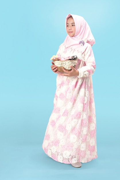 Niña hijab en vestido con canasta