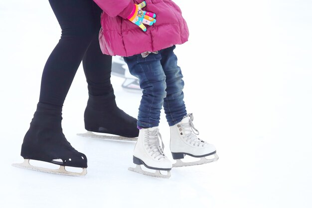 Niña y hombre adulto patinando sobre hielo