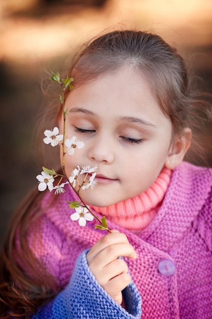 Niña huele flores de cerezo