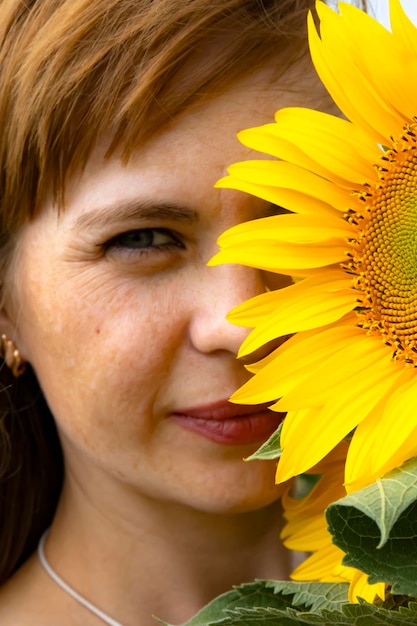 Una niña huele un girasol en un campo. foto de alta calidad