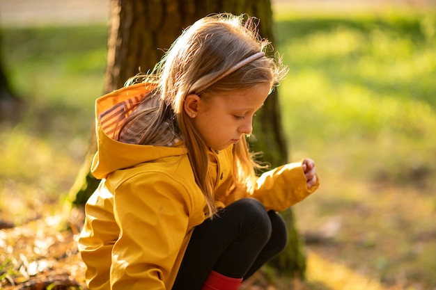 Una niña con un impermeable amarillo y gorras rojas encontró un hongo