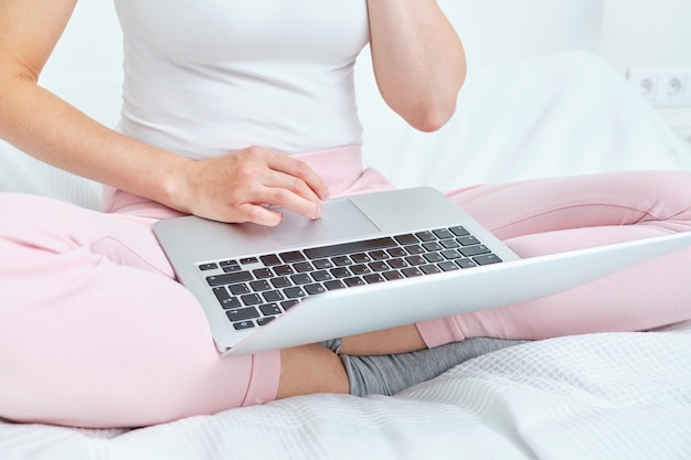 Una niña imprime en un teclado de computadora portátil