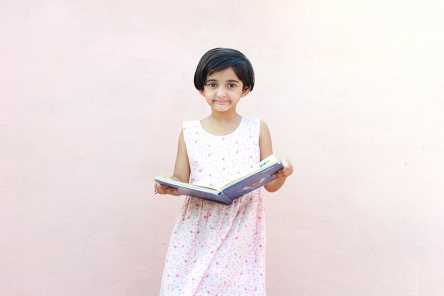 Niña india escribiendo en cuaderno, estudiando