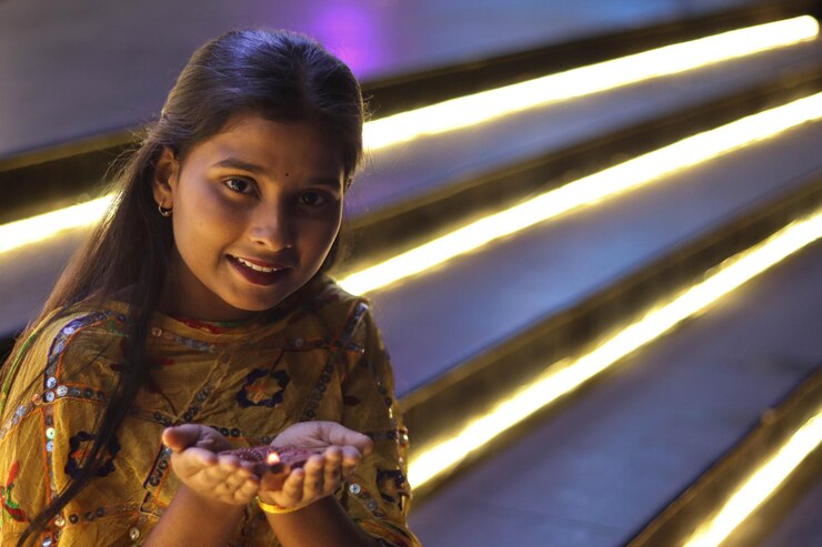 Niña india sosteniendo diya en la mano para el festival indio de Diwali