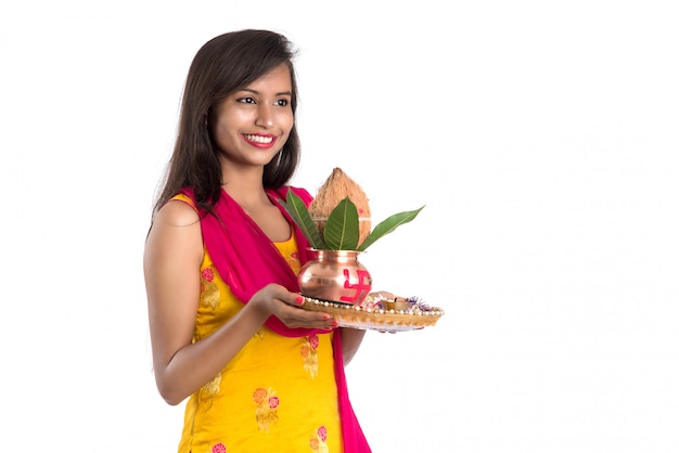 Niña india sosteniendo un Kalash de cobre tradicional con Pooja Thali, Festival de la India, Kalash de cobre con hojas de coco y mango con decoración floral, esencial en la Pooja hindú.