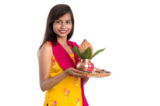 Foto niña india sosteniendo un kalash de cobre tradicional con pooja thali