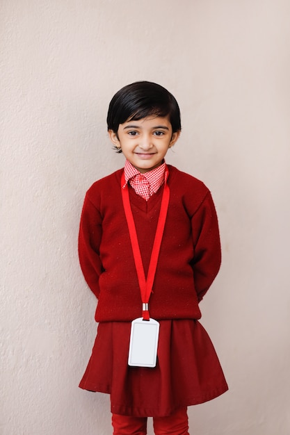 Foto niña india en uniforme escolar y mostrando expresión