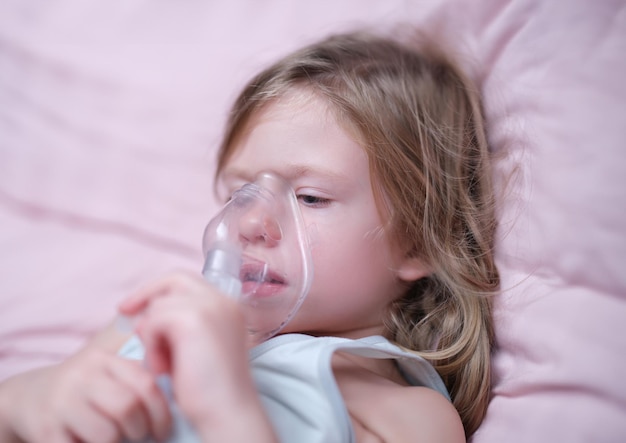 Niña inhalando un medicamento hormonal con un nebulizador