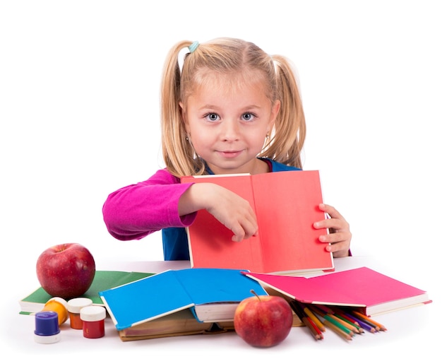 Niña inteligente sosteniendo un libro y leyéndolo sobre un fondo blanco