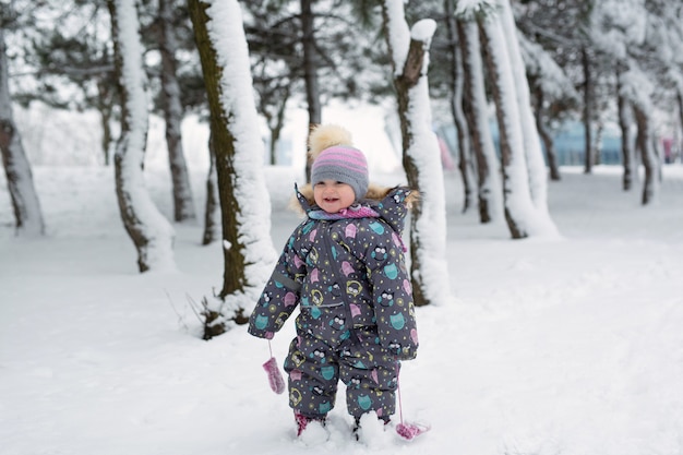 Niña en invierno en un bosque nevado.