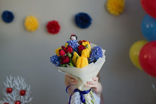 Una niña irreconocible sostiene un ramo de flores en sus manos.