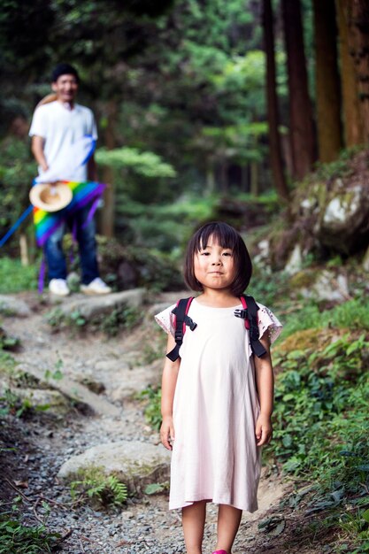 Niña japonesa con vestido de sol rosa pálido y mochila de transporte