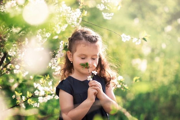 niña en el jardín con árboles florecientes