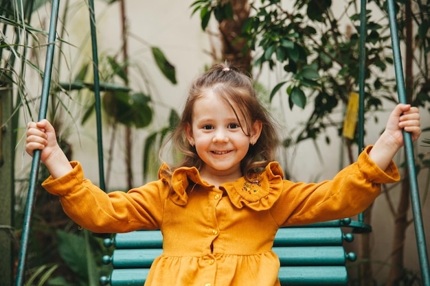 Niña en el jardín botánico Retrato de primer plano de un niño con el concepto de belleza de la salud del cabello oscuro