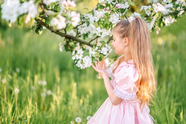 Niña en el jardín de flores de primavera