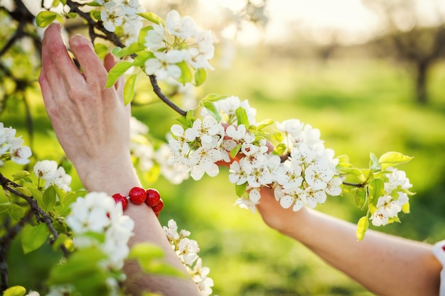La niña en el jardín florido Mañana de primavera en un hermoso jardín Rama florida en sus manos