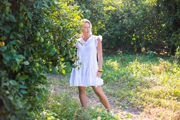 Niña en el jardín con frutas naranjas