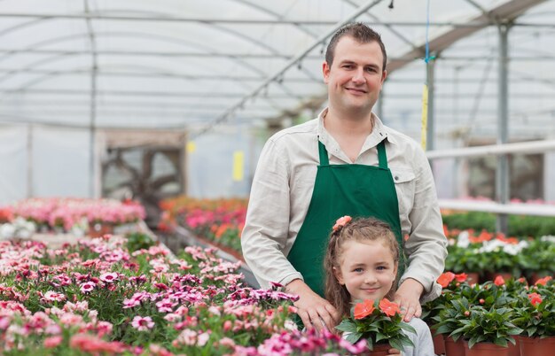 Niña y jardinero en invernadero