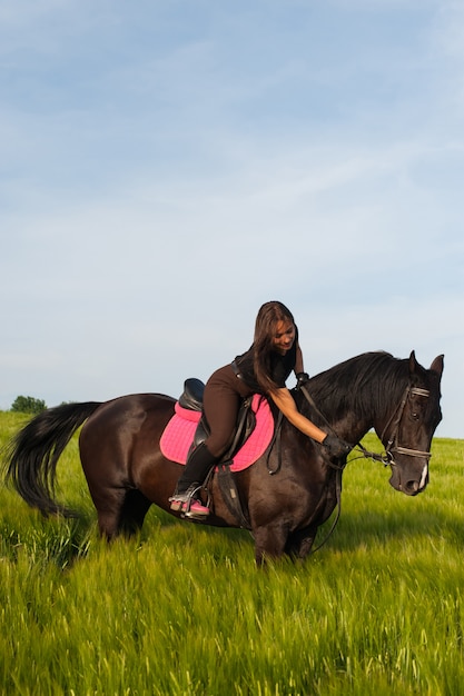 Foto una niña y un joven caballo deportivo en la naturaleza