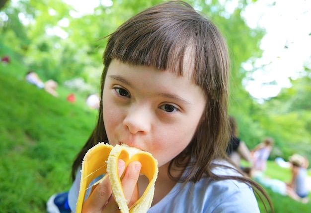 niña joven, comida, plátano, en el parque